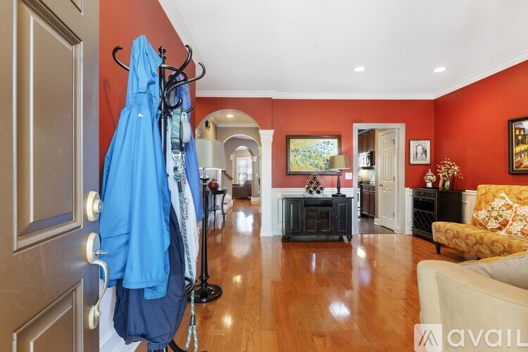 A hallway with a coat rack and a blue coat hanging on it.
