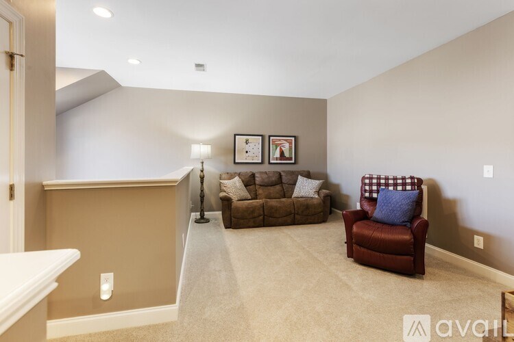 A living room with a brown couch and a red chair.