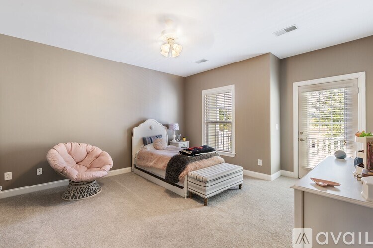 A bedroom with a bed, chair, and window.