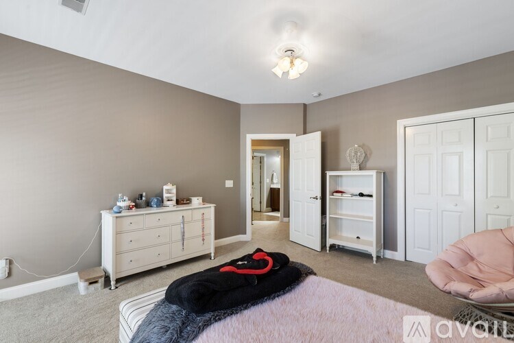 A bedroom with a bed, dresser, and wardrobe.