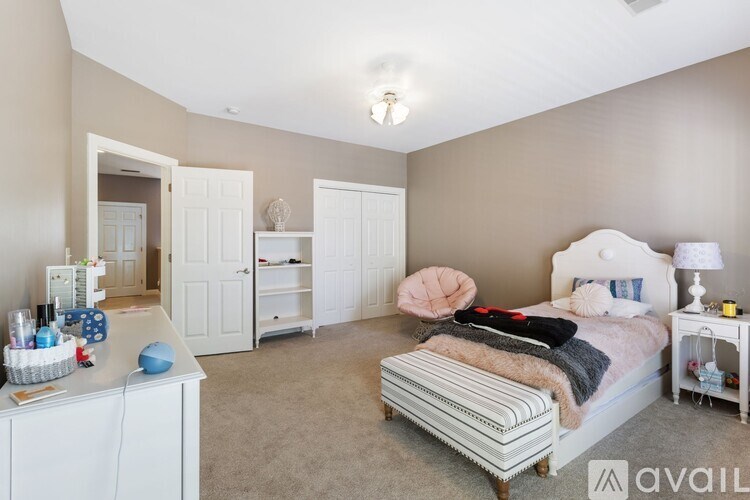 A bedroom with a bed, nightstand, and a dresser with a mirror.