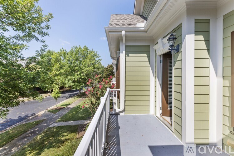 A house with a green siding and a white porch.