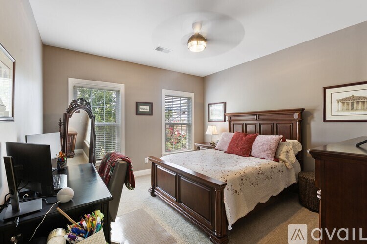 A bedroom with a large bed and a desk with a computer.