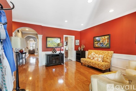 A living room with a yellow sofa and a painting on the wall.