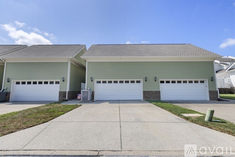 A two-story house with a garage and a driveway in front.