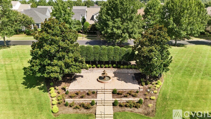 A well-maintained garden with a circular fountain at its center.