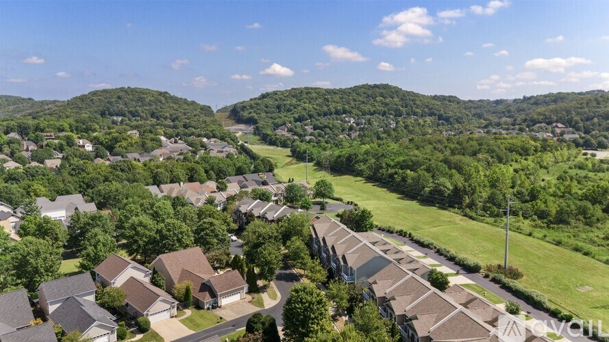 A bird's eye view of a residential area with houses and greenery.