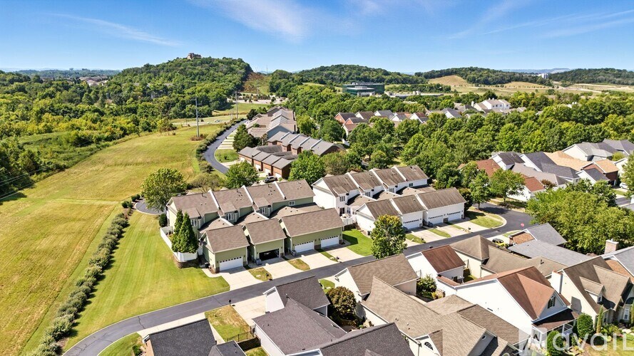 A bird's eye view of a residential area with houses and greenery.