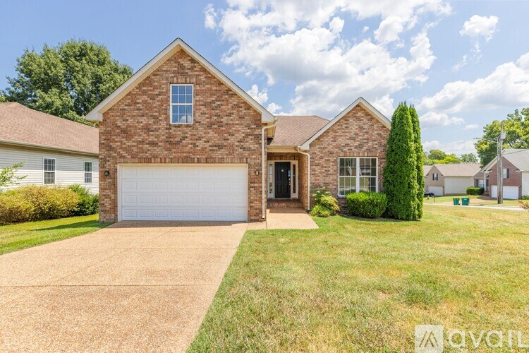 A brick house with a white garage door is for sale.