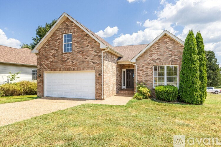 A brick house with a white garage door and a driveway.