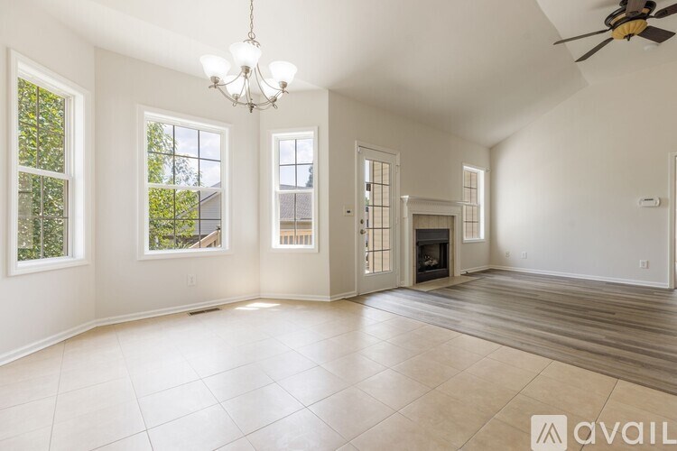 A spacious room with a fireplace and a chandelier.