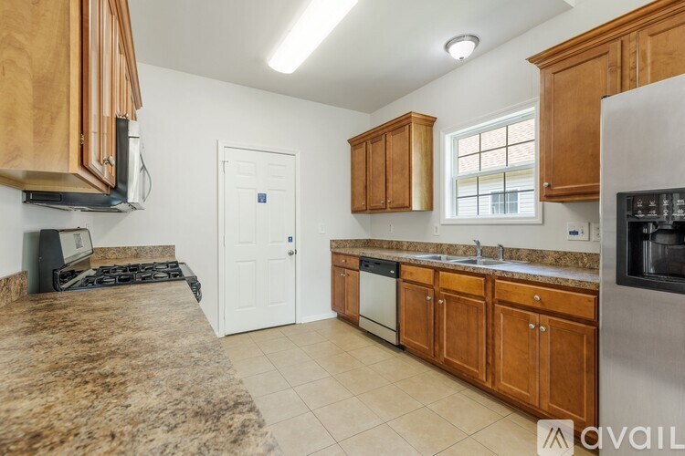 A kitchen with wooden cabinets and a granite countertop.