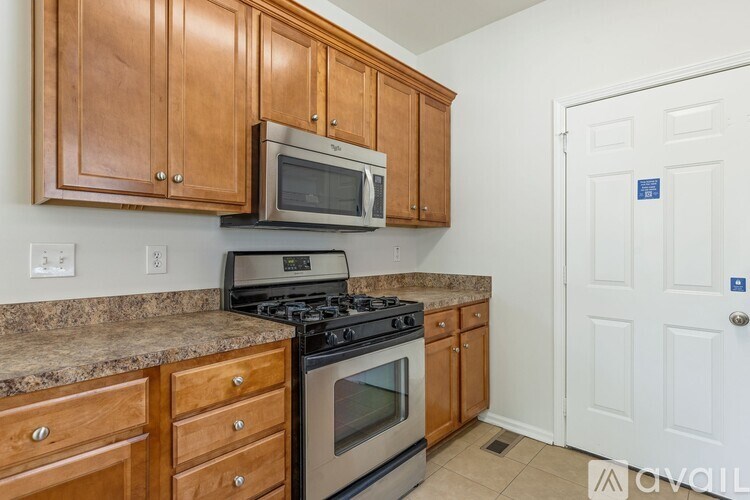 A kitchen with wooden cabinets and a granite countertop.
