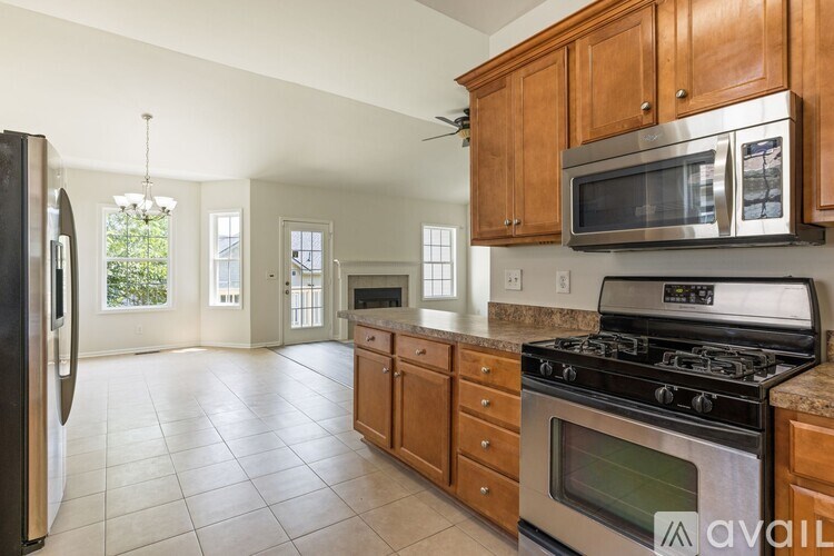 A kitchen with wooden cabinets and a black refrigerator.