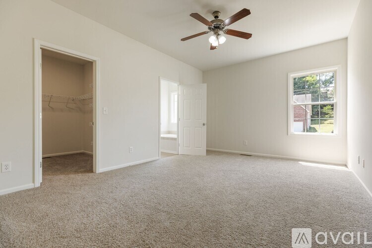A spacious room with a ceiling fan and a window.