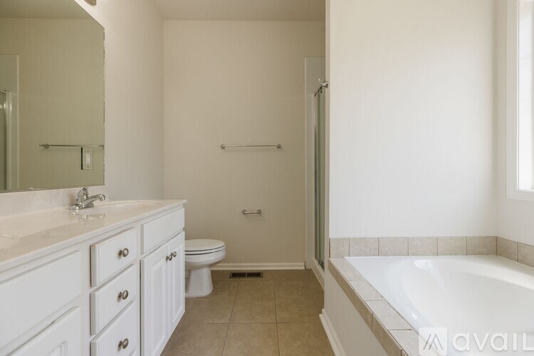 A white bathroom with a tub, toilet and sink.