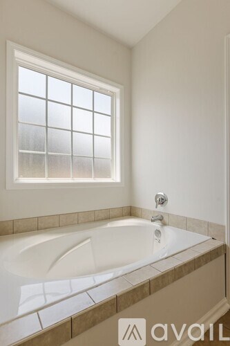 A bathroom with a tub and a window.