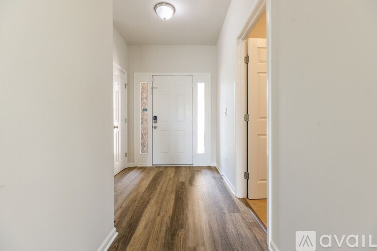 A long hallway with a wooden floor and white walls.