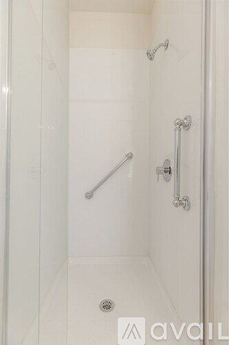 A white bathroom shower with a glass door.