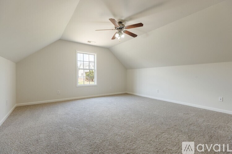 A room with a ceiling fan and a window.