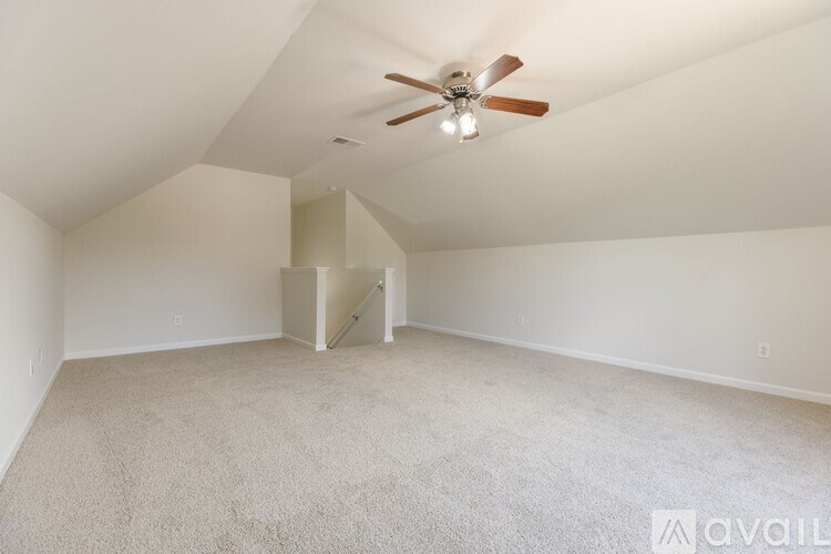A room with a ceiling fan and carpeted floor.