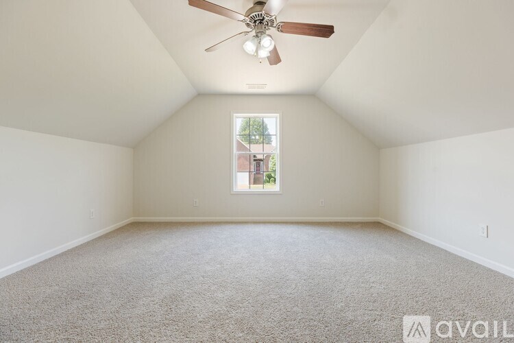 A room with a ceiling fan and carpeted floor.