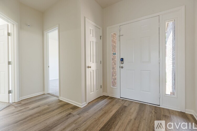 A room with white doors and wooden flooring.