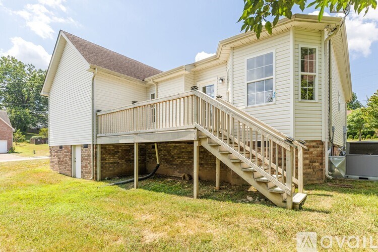 A house with a deck and stairs leading to the second floor.