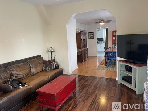 A living room with a brown couch and a red box on the floor.