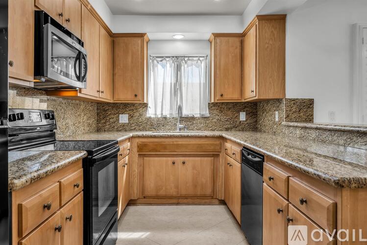A kitchen with wooden cabinets and granite countertops.