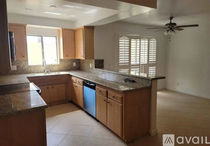 A kitchen with wooden cabinets and granite countertops.