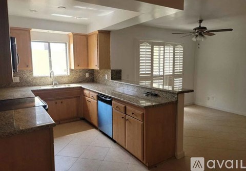 A kitchen with wooden cabinets and granite countertops.