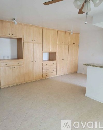 A room with wooden cabinets and a ceiling fan.