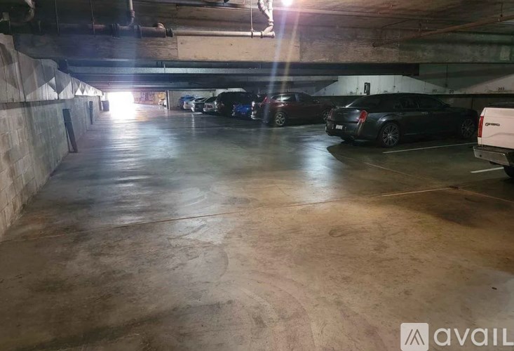 A parking garage with a few cars parked in it.