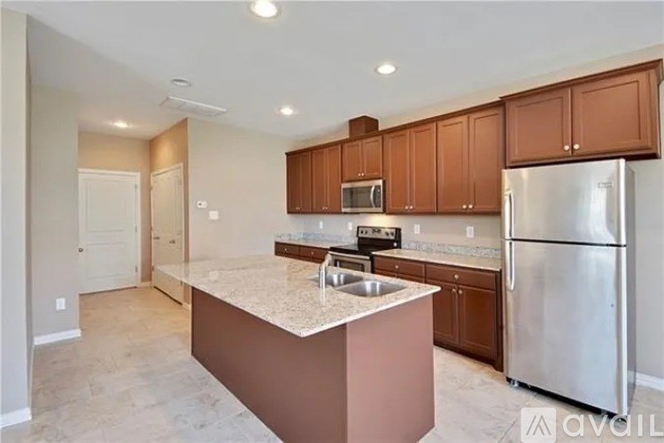 A kitchen with brown cabinets and a stainless steel refrigerator.