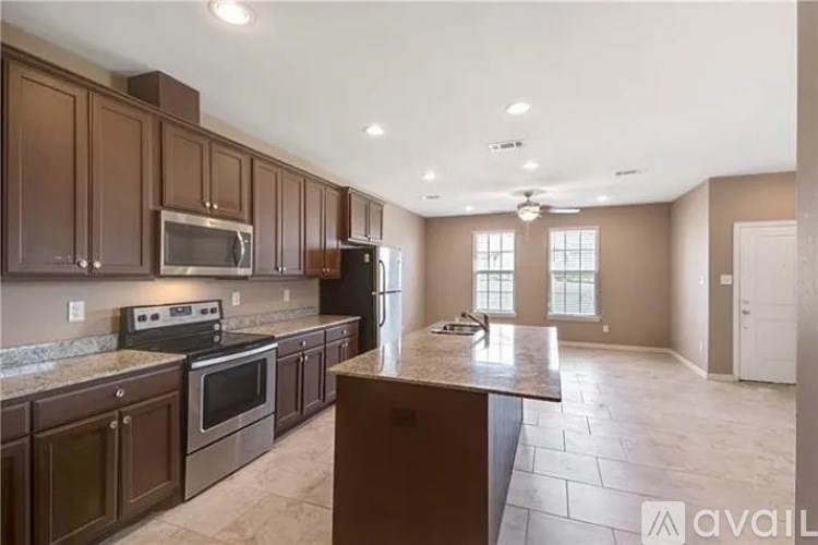 A kitchen with brown cabinets and a marble countertop.