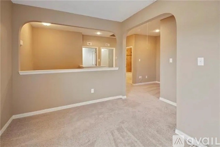 A spacious room with a large mirror and carpeted floor.