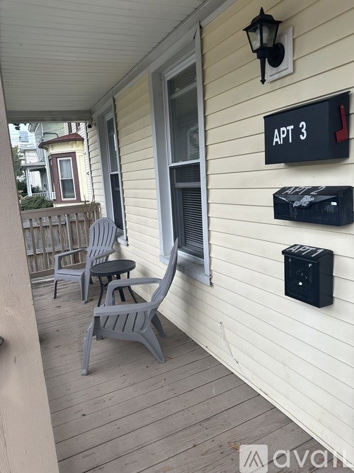A porch with two chairs and a table.