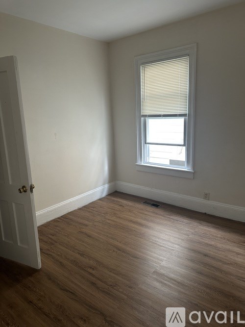 A room with a door and a window with blinds.