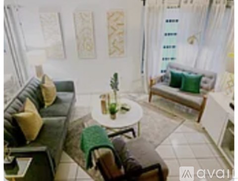 A living room with a couch, a chair, and a table with a plant on it.