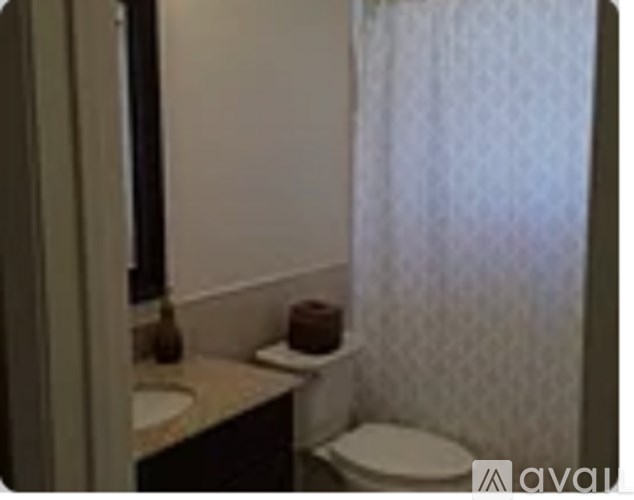 A small white toilet sits next to a sink in a bathroom.