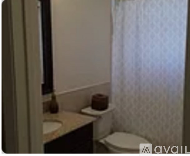 A white toilet sits next to a sink in a bathroom.