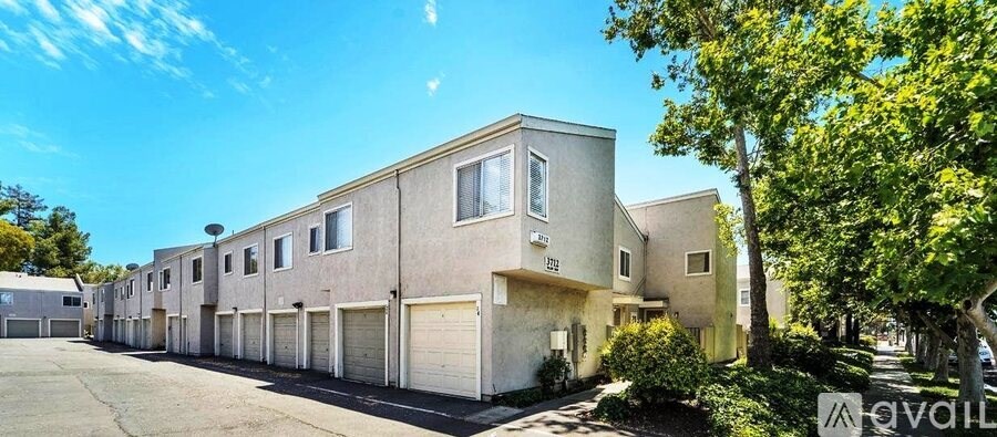 A row of townhouses with garages are for sale.