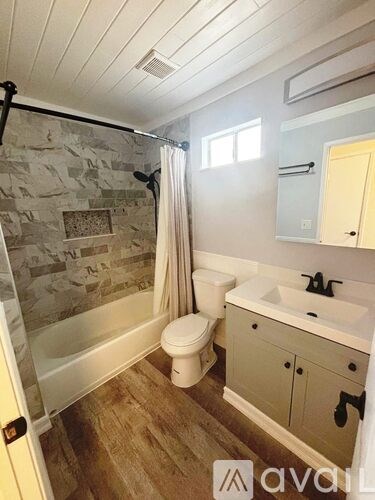A bathroom with a stone wall and a toilet.