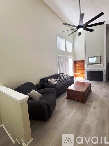 A living room with a black couch and a wooden coffee table.