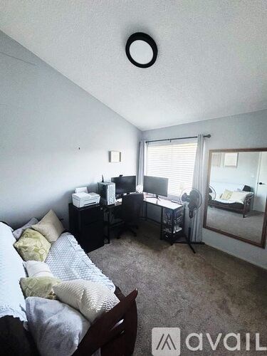 A bedroom with a bed, desk, and chair.