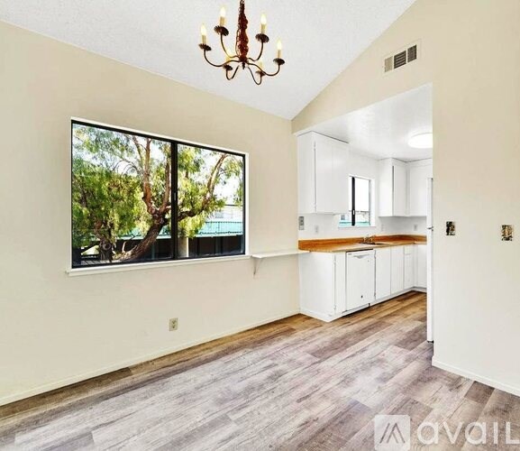 A room with a large window and a chandelier.