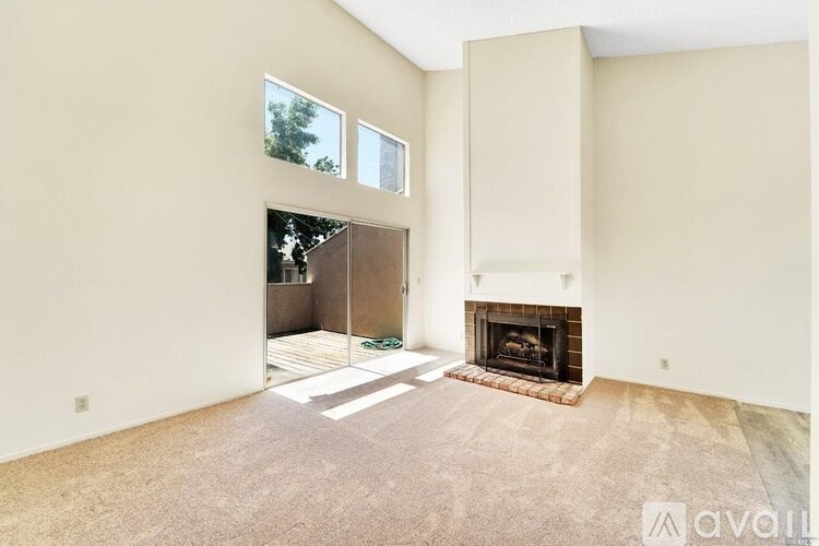 A living room with a fireplace and a carpeted floor.