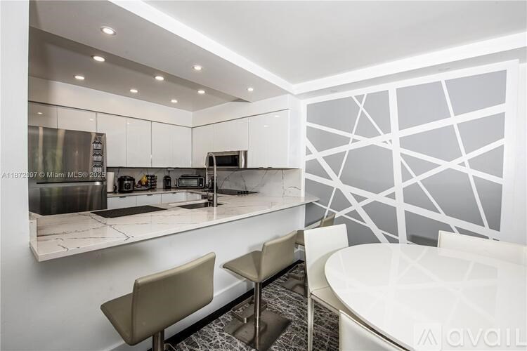 A modern kitchen with a bar area and a dining table.