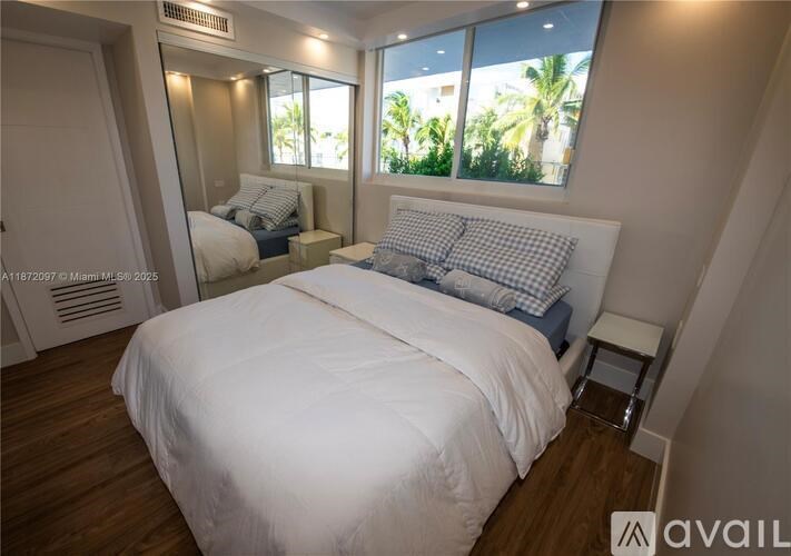 A bedroom with a large bed and a window overlooking a balcony.